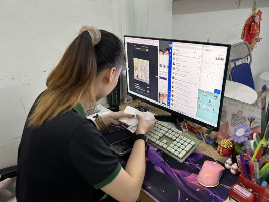 Nhân viên công ty đang tư vấn cho khách hàng về dịch vụ in menu